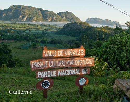 a sign in a field with mountains in the background at Casa Carlos Valido in Viñales