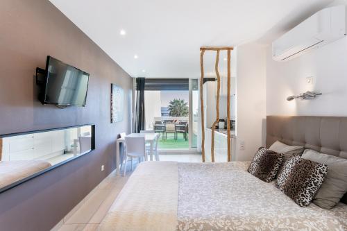 sypialnia z łóżkiem i telewizorem na ścianie w obiekcie Java Heliopolis naturiste w Cap d'Agde