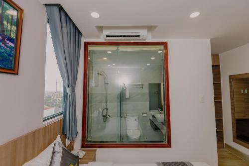 a bathroom with a glass shower and a toilet at Royal Palms Hotel in Tuy Hoa
