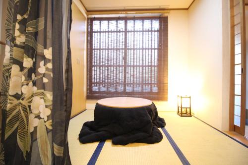 ein Zimmer mit einem Tisch in der Mitte eines Zimmers in der Unterkunft TRAD GUEST HOUSE KYOTO Kyomachiya in Kyoto