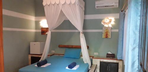 a bedroom with a bed with a canopy at Mangga Lodge in Bira