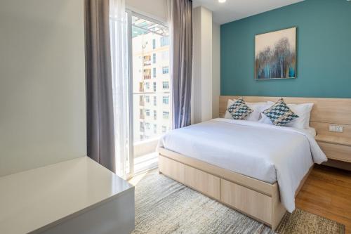 a bedroom with a bed and a large window at Helen Fin Inn & Apartment in Phnom Penh