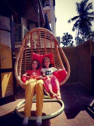 two girls are sitting in a hanging basket at Canal's Edge in Negombo