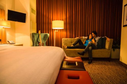 
a woman sitting on a couch in a living room at Seminole Hard Rock Hotel and Casino Tampa in Tampa

