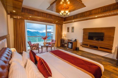 um quarto com uma cama grande e uma janela grande em The Retreat Mashobra, Shimla em Shimla