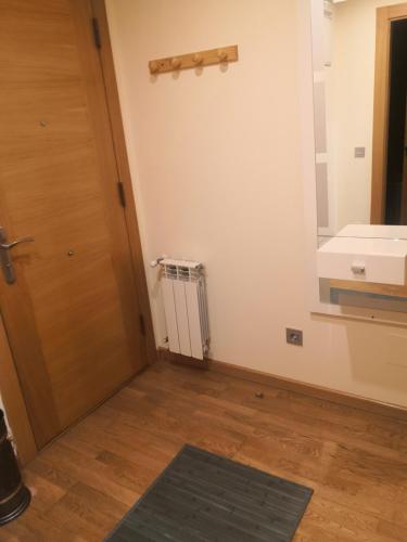 a bathroom with a door and a sink and a rug at Apartamentos Chevere Azul con Garaje in Oviedo