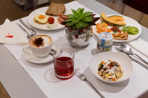 a table with plates of food and a cup of coffee at La Ciliegina Lifestyle Hotel in Naples
