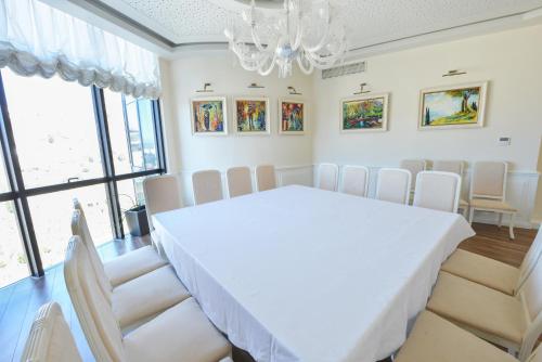 a dining room with a white table and chairs at Jolly Hotel in Lezhë