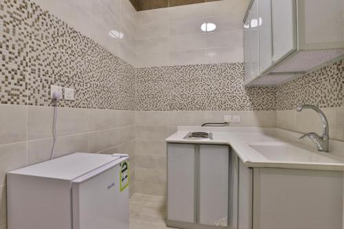 ein weißes Badezimmer mit einem Waschbecken und einem Geschirrspüler in der Unterkunft Moon Gate 2 in Yanbu
