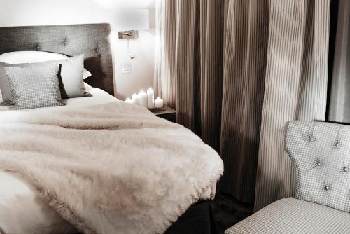 a bedroom with a white bed and a chair at Maison D'Anthouard in Écully