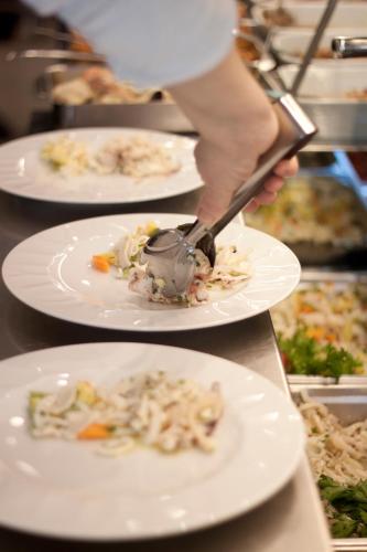 a person is serving food on plates on a table at La Lanterna in Silvi Marina