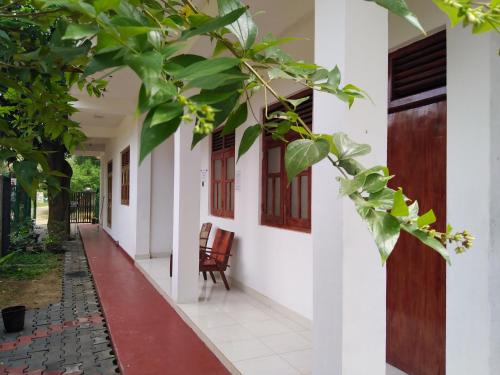 un pasillo de una casa con una puerta y una silla en Dinesh Guest House, en Kataragama