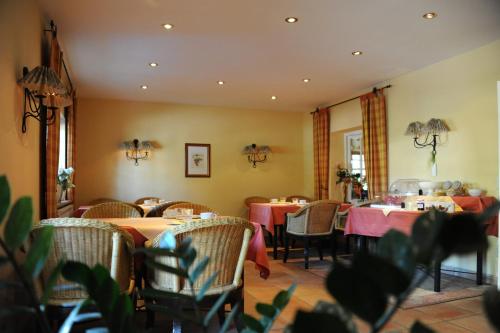 ein Restaurant mit Tischen und Stühlen mit rosa Tischtuch in der Unterkunft pension Helga in Bad Dürkheim