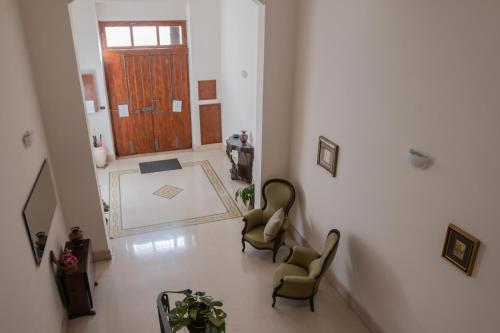 a hallway with two chairs and a wooden door at Dimora Apulia in Brindisi