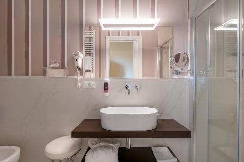 a bathroom with a sink, toilet and bathtub at Grand Hotel Tettuccio in Montecatini Terme