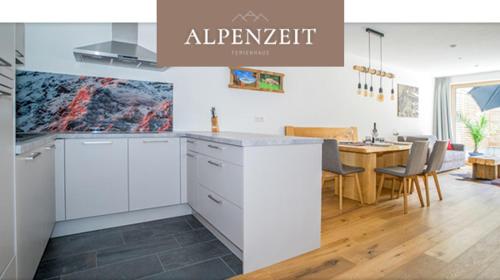 una cucina con armadi bianchi e una sala da pranzo di Alpenzeit a Ladis