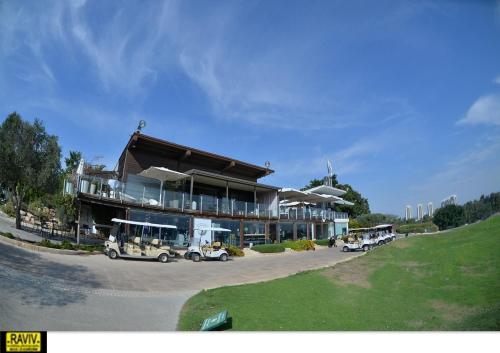 a large building with cars parked in a parking lot at Royal Suite Caesarea in Caesarea