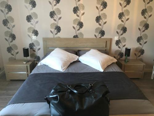 a bedroom with a bed with a black purse on it at Maison d'hôtes La Colombelle in Colombé-le-Sec