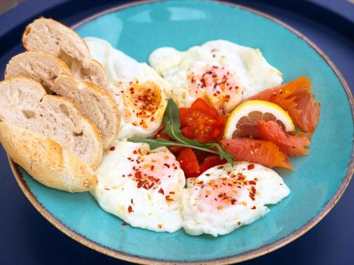 een blauw bord met eieren, brood en groenten bij Pergola Boutique Hotel in Boekarest