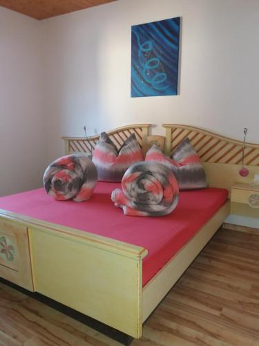 ザンクト・ミヒャエル・イム・ルンガウにあるHaus Santorumのベッドルーム1室(木製ベッド1台、赤いシーツ、枕付)