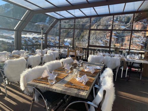 a dining room with tables and chairs with a view at La Bournerie in Le Grand-Bornand