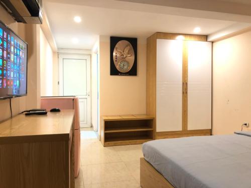 um quarto com uma cama e um relógio na parede em TrangTien Hostel em Hanói