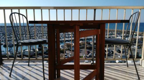 a balcony with two chairs and a view of a harbor at Les Aigues Marines - belle vue mer et port in Palavas-les-Flots