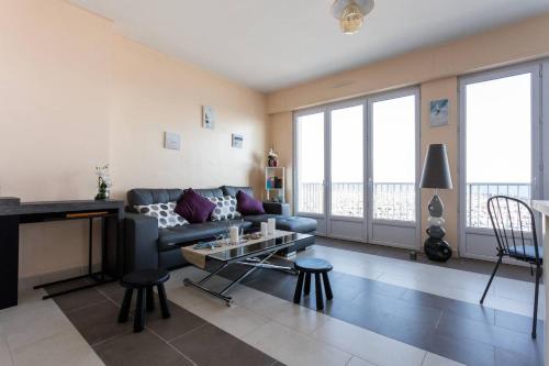 a living room with a couch and a table at Les Aigues Marines - belle vue mer et port in Palavas-les-Flots