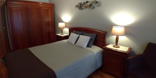 1 dormitorio con 1 cama con 2 mesitas de noche y 2 lámparas en Apartamento Galerias, en Oporto