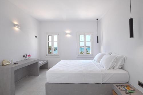 a white bedroom with a bed and a desk at The view 3 in Santa Marina