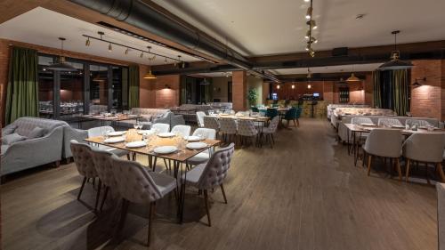 a restaurant with tables and chairs in a room at KOMOREBI BAKURIANI RESORT in Bakuriani