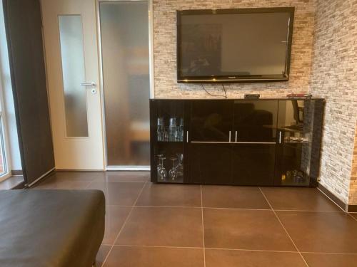a living room with a flat screen tv on a brick wall at Ferienwohnung 210 Vitamar in Schmarren