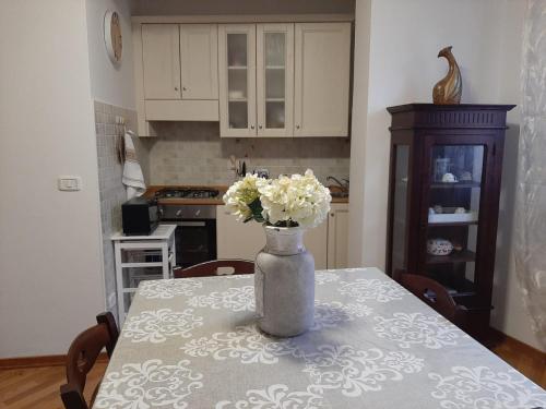 - une table avec un vase et des fleurs blanches dans l'établissement Tra i due ponti, à Rieti