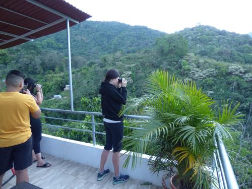 a group of people taking pictures of the mountains at Hostal Alto de la Montaña in Minca