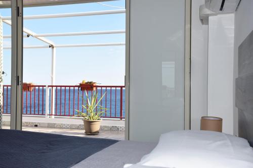 um quarto com uma cama e uma varanda em Ionio Sea Apartment em Marina di Gioiosa Ionica