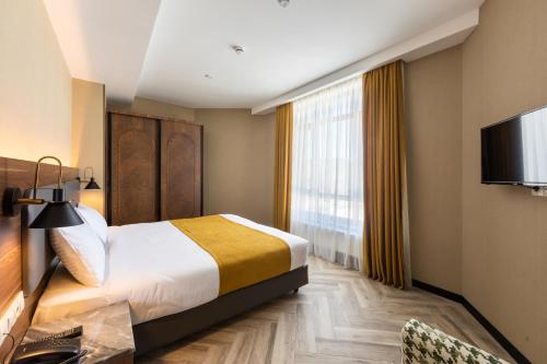 a hotel room with a bed and a television at KOMOREBI BAKURIANI RESORT in Bakuriani