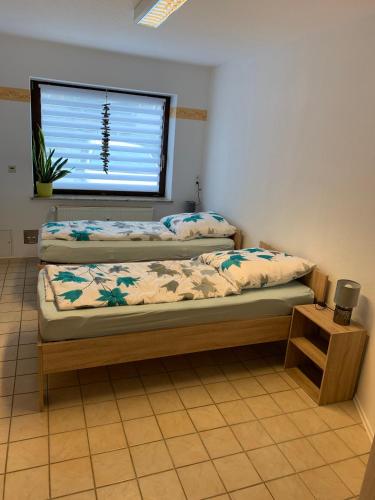 two twin beds in a room with a window at Ferienwohnung Buddha in Langelsheim