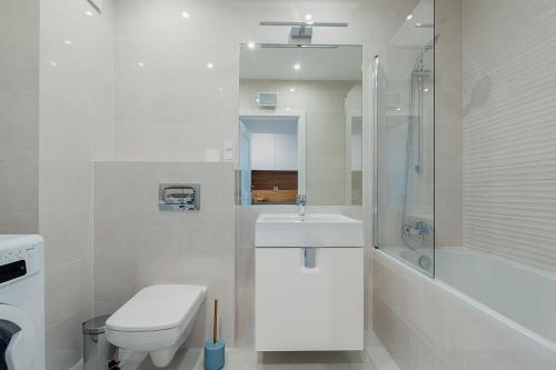 bagno bianco con servizi igienici e lavandino di Warsaw To Be - Blue Apartment a Varsavia