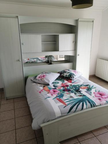 - une chambre avec un lit fleuri dans l'établissement CHEZ MARTINE Appt climatisé 2 Chambres, à Capbreton