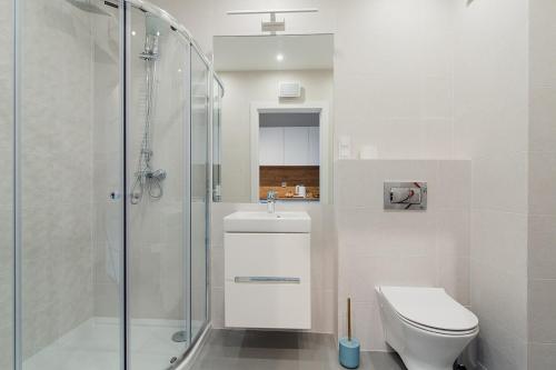 a bathroom with a shower and a toilet and a sink at Warsaw To Be - Silver Apartment in Warsaw