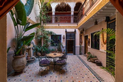 een binnenplaats met een tafel en stoelen in een gebouw bij RIAD MAKENE MOUCHKILL in Marrakesh