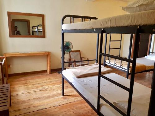 a room with two bunk beds and a mirror at Railway Lodge Hostel in Hatton