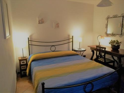 a bedroom with a bed and a desk and a mirror at Il Molino Di Serravalle in Bibbiena