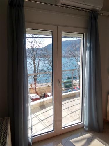 a glass door with a view of the water at CK Lake View in Kastoria