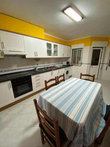 a kitchen with a blue and white table and chairs at OCEAN VIEW Quartos in Faro