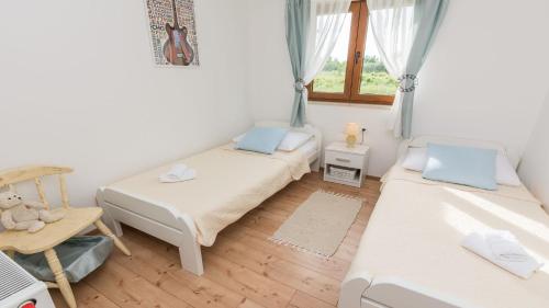 mały pokój z 2 łóżkami i oknem w obiekcie Villa Mia with heated pool, billiards and large garden - by TA Leut Agency w mieście Privlaka