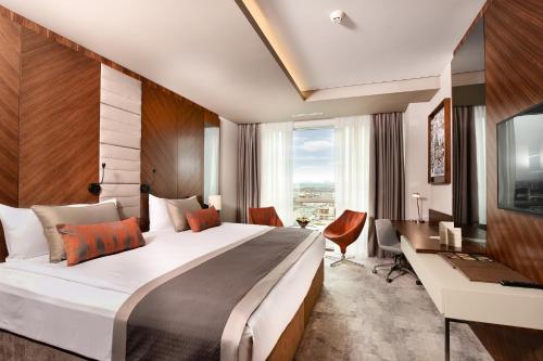 a hotel room with a large bed and a desk at Ankara Alegria Business Hotel in Ankara