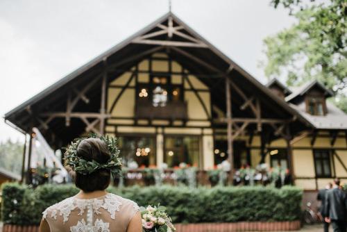 a woman is standing in front of a building at Penzion Obora in Poděbrady