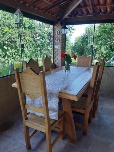 a wooden table with chairs and a vase of flowers at Pousada Capão do Mel in Ibicoara
