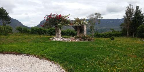 a garden with a stone structure with flowers on it at Pousada Capão do Mel in Ibicoara